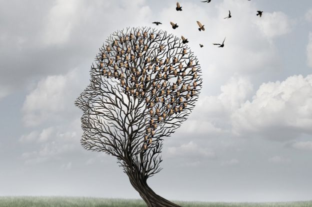 Memory loss concept of head-shaped tree with birds flying out of it