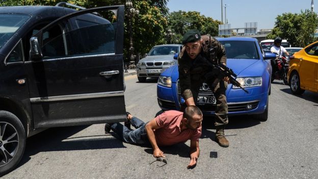 A Turkish police officer restrains a man on the ground during an operation in front of the Ankara courthouse - 18 July 2016.