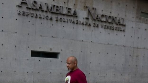 A pedestrian walks in front of the administrative offices of the Venezuela National Assembly in downtown Caracas on 4 January 2016
