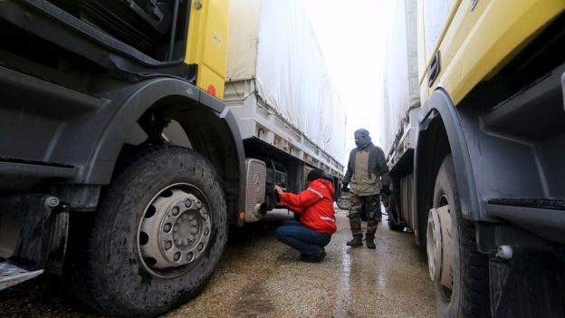 Rebel fighter inspects Red Crescent vehicles on their way to Foua and Kefraya, Syria (11 January)