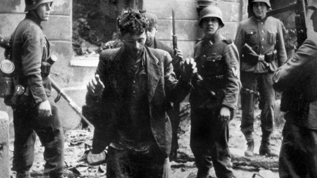 Nazi soldiers arrest a Jew after the Warsaw ghetto uprising in 1943