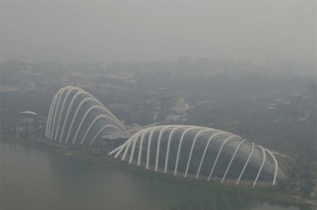 A view of the Flower Dome and Cloud Forest conservatories of Gardens by the Bay and the southern coast of Singapore shrouded by haze in Singapore 10 September 2015