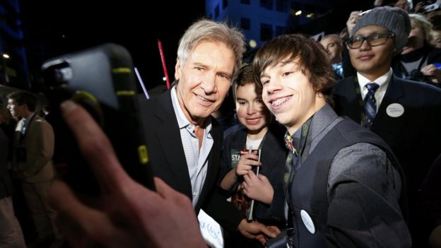 Harrison Ford poses with a fan at the Star Wars premiere