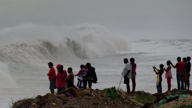 Jamaiquinos observan el oleaje que provocaba el huracán Matthew