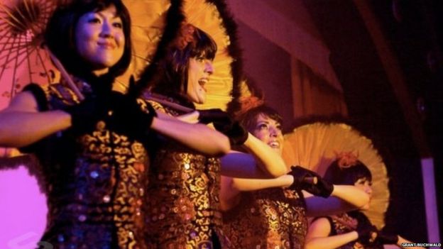 Showgirls perform with parasols