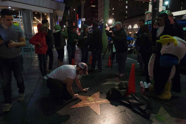 A man cleans the star for Debbie Reynolds on the Hollywood Walk of Fame in Hollywood, California, 28 December