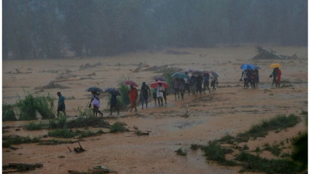 Villagers walk through rain, mud and ankle-deep water, after the landslide. Photo taken 18 May 2016.