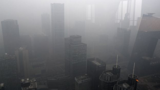 12月20日，北京國貿大酒店，一位女士在玻璃窗中的背影和國貿周圍的霧霾。