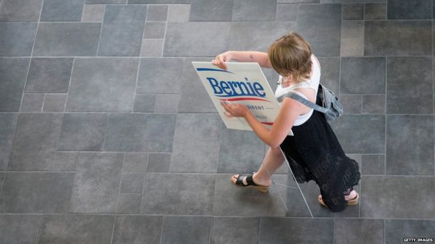 A supporter of Bernie Sanders carrying a sign reading 'Bernie for president' in Iowa