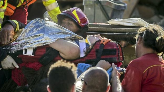 An injured woman is carried by rescuers in Amatrice, central Italy, where a 6.1 earthquake struck, Italy (24 August 2016)