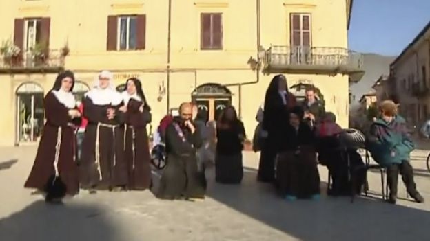 Priests and nuns join residents in the main square in Norcia after being evacuated from church on Sunday, 30 October 2016