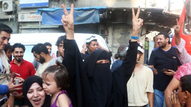 A woman flashes the victory sign as she celebrates the news of the breaking of the siege of rebel-held areas of Aleppo