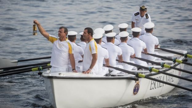 Olympian Lars Grael (L) carries the Olympic flame aboard a Brazilian Naval Academy boat during the Olympic Torch relay ahead of the Rio 2016 Olympic Games on August 3, 2016 in Rio de Janeiro, Brazil.