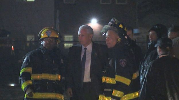 Mike Pence talks with firefighters at New York's LaGuardia Airport
