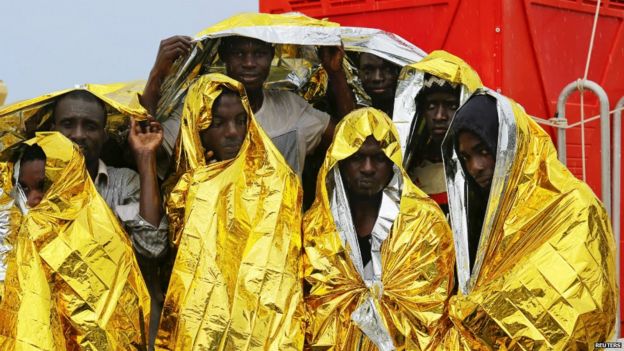 Migrants wait to disembark from an Italian coast guard ship in the Sicilian harbour of Messina, Italy - 4 August 2015