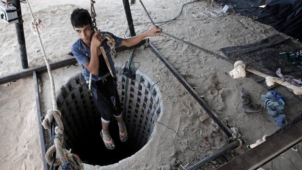 A Palestinian youth descends into one of the tunnels on the Gaza side of the border with Egypt in Rafah (19 September 2015)