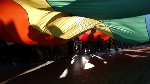 People hold a giant rainbow flag as they participate in the annual gay pride parade in Athens, Greece, 11 June 2016