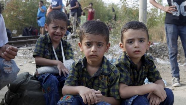 Three boys migrants wait for the rest of their family to enter into Macedonia from Greece