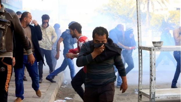 أحد المتظاهرين في بغداد يغطي وجهه بعد اطلاق قوات الأمن الغاز المسيل للدموع