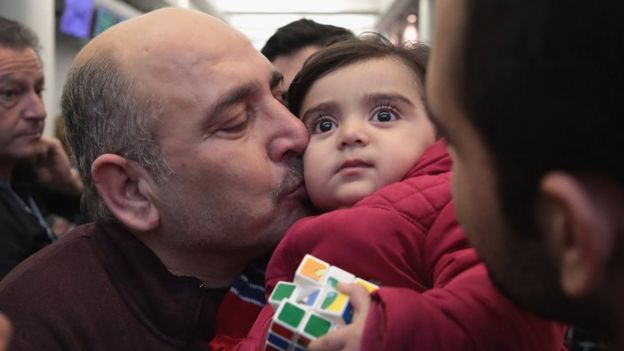 Khaled Haj Khalaf kisses his granddaughter Shams after she arrived with her mother and father at O'Hare Airport on a flight from Istanbul, Turkey on February 7, 2017 in Chicago, Illinois.