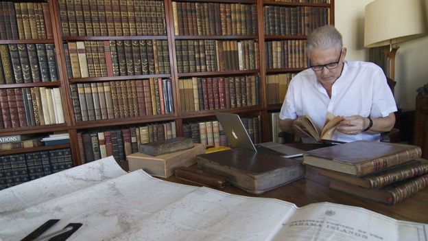 Josiah Marvel studying documents related to Columbus' voyage