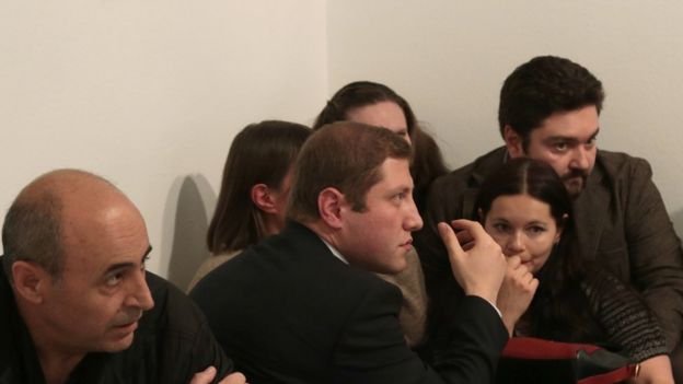 People crouch in the exhibition room after the shooting in Ankara, 19 December