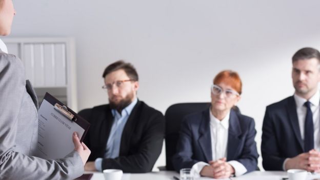 Una joven que se enfrenta a un panel de entrevistadores