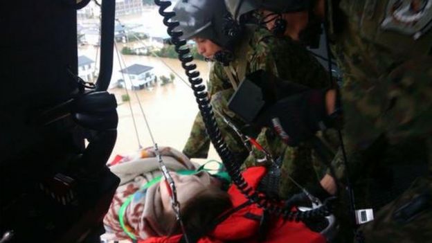 An injured person is lifted to safety by Japanese troops