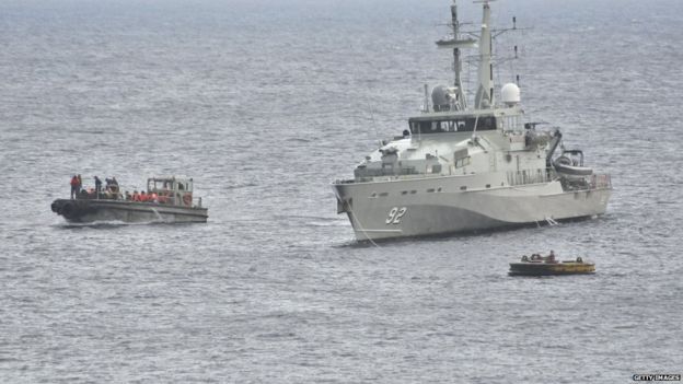 An Australian navy vessel and smaller boats