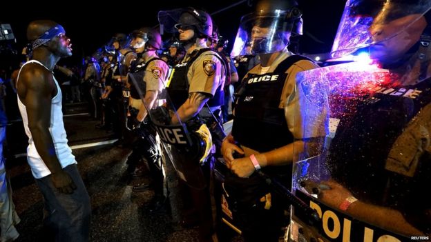 A protester yells at a police line shortly before shots were fired in a police-officer involved shooting in Ferguson, Missouri August 9, 2015.