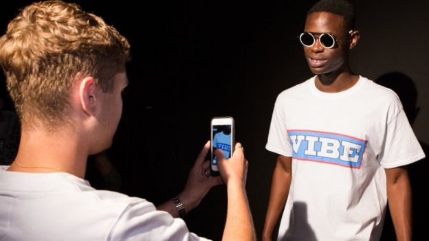 Boy photographing friend's T-Shirt