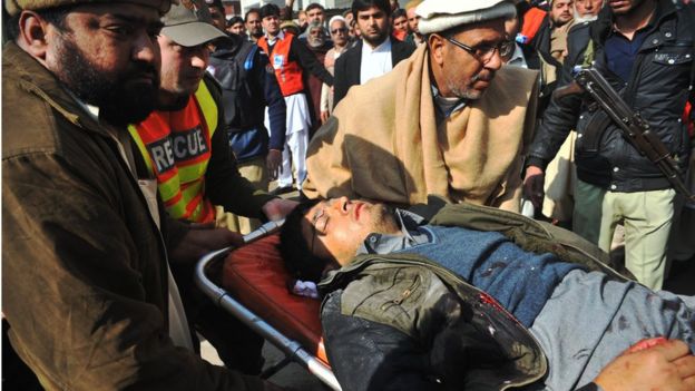 Rescuers take a man to hospital in Charsadda, Pakistan, 20 January