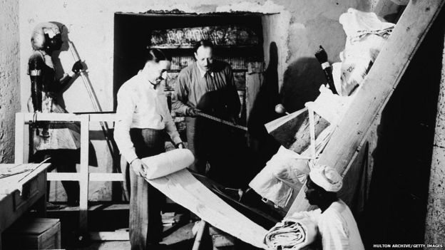 British archaeologists Howard Carter (1874 - 1939) (left) and Arthur Callender (died 1937) carry out the systematic removal of objects from the antechamber of the tomb of Pharaoh Tutankhamen, better known as King Tut, with the assistance of an Egyptian laborer, Valley of the Kings, Thebes, Egypt, 1923