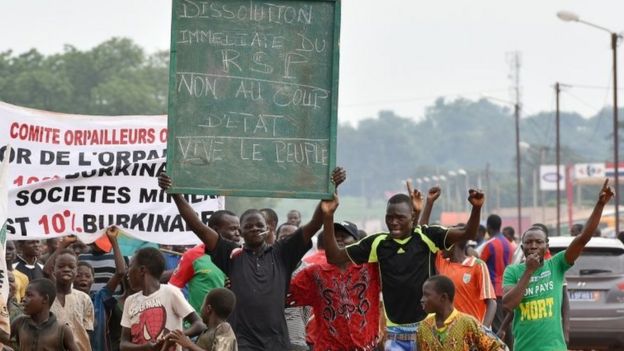 A man holds a placard that reads, 