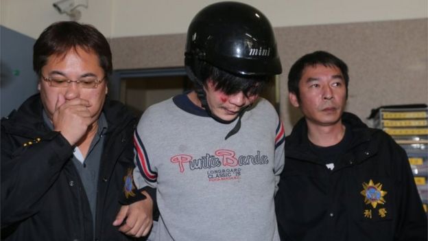 This photo taken on March 28, 2016 shows police escorting a man (C) who allegedly attacked and murdered a Taiwanese toddler along a street in Taipei, sending shock waves through the island.