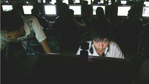 Jovem asiático em frente a computadores