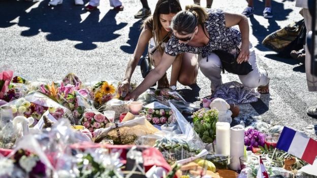 People placing candles among the tributes in Nice