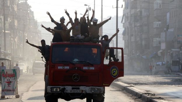 Rescue workers celebrate in Aleppo, 6 August