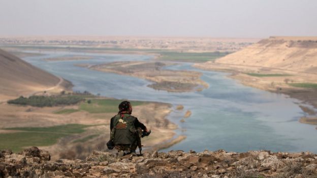 A Syrian Democratic Forces (SDF) fighter rests while looking over the Euphrates River, north of Raqqa city, Syria 8 March 2017