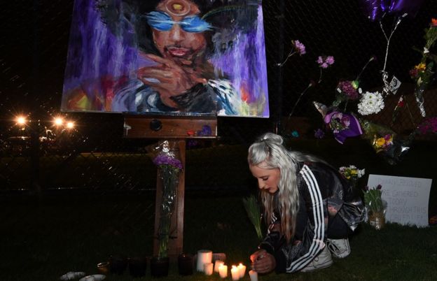 Fans light candles outside the Paisley Park residential compound of music legend Prince in Minneapolis, Minnesota, on April 21, 2016