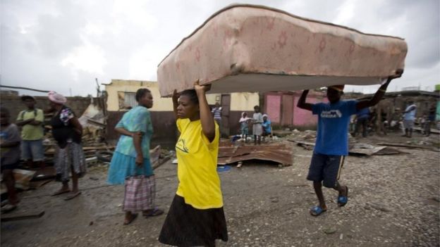 Residentes de Les Cayes trasladan un colchón a un refugio.