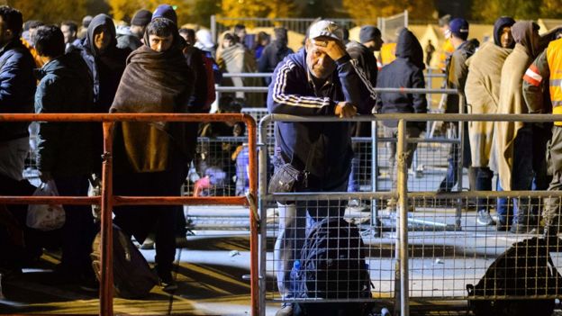 Migrants wait to board a bus for refugee centres on the Austrian side of the border between Sentilj, Slovenia, and Spielfeld, Austria. 17 Oct 2015