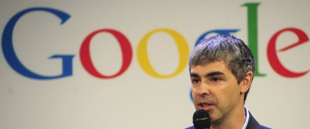 Google founder speaking in front of Google sign