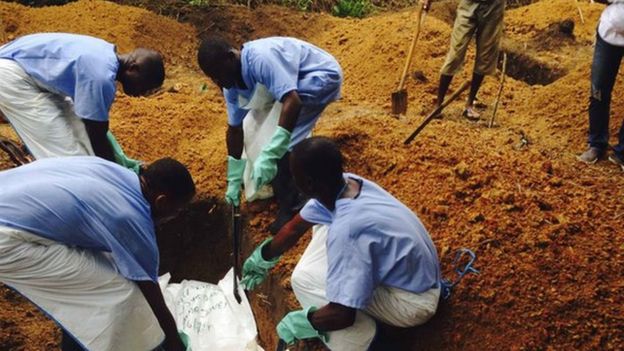 Volunteers bury the body of an Ebola victim in Sierra Leone