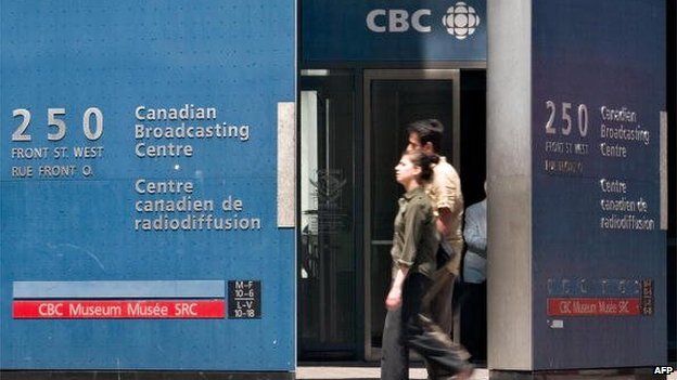 Pedestrians walk past CBC building in Toronto