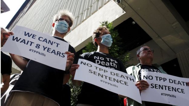 Supporters and individual patients living with cancer including (L-R) John Fortivin, Zak Norton and Greg Ames, protest outside the hotel where the Trans-Pacific Partnership Ministerial Meetings are being held in Atlanta, Georgia, September 30, 2015.
