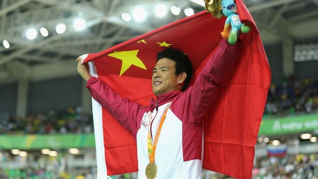 Gold medalist Zhangyu Li of China celebrates on the podium at the medal ceremony for the Men's C1-2-3 1000m