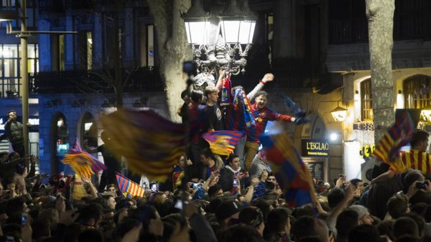 شادی طرفداران بارسلونا در کنار چراغی که معمولا پس از پیروزی‌های بزرگ تیمشان جشن می‌گیرند