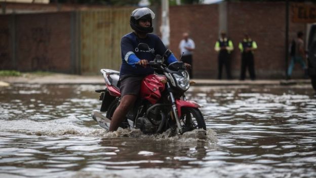 Un motociclista recorriendo una calle de Sullana, en la región Piura, inundada a fines de febrero.