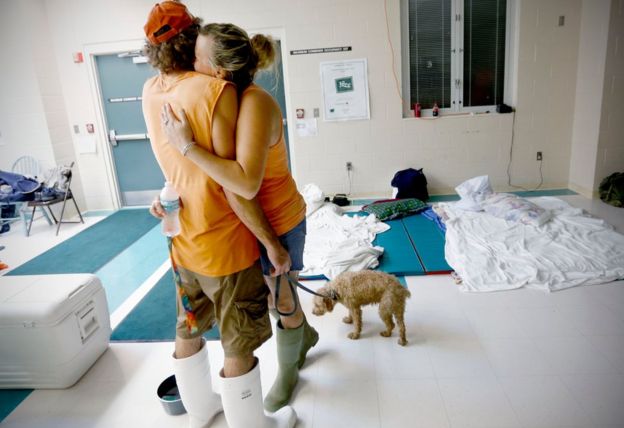 Chris Hacker, left, hugs his girlfriend Lyn Charlton after the couple arrived at an elementary school with their dog on Friday, Sept. 2, 2016 in Steinhatchee, Fla